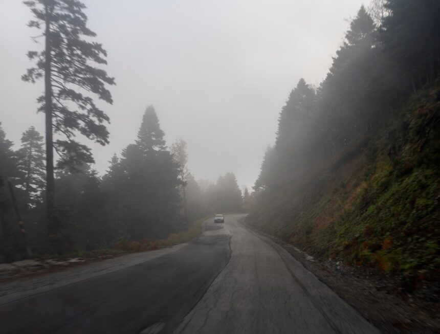 Urban Legends: 9 Tales Where Familiar Places Turn Dark A car on a foggy road winding through forested mountains on Evia, Greece.
