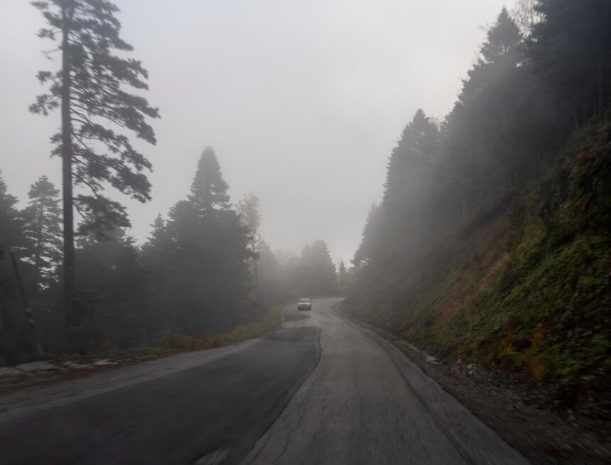 Urban Legends: 9 Tales Where Familiar Places Turn Dark A car on a foggy road winding through forested mountains on Evia, Greece.