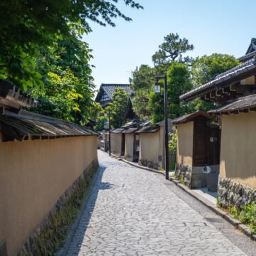 Japanese Urban Legends: A Mask, a Question, a Trap An empty stone-paved street lined with plaster walls and tiled roofs in Nagamachi, Kanazawa, Japan.