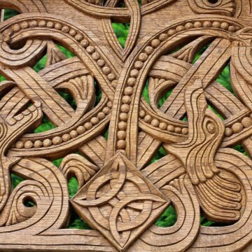 Norse Mythology Creatures: Kin and Killers of the Gods Intricate wooden carving with intertwined animal forms, looping serpents and a central knot.